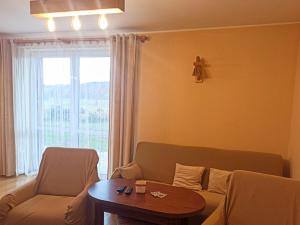 WitanowiceHoliday Home Lgota by Interhome的带沙发、桌子和窗户的客厅