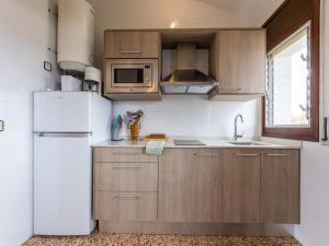 托里代巴拉Apartment Drassanes III by Interhome的厨房配有木制橱柜和白色冰箱。