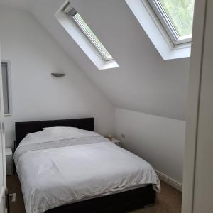 贝肯翰姆2-Bed Loft Apartment for 5ppl with private parking的卧室设有白色墙壁和2个天窗。