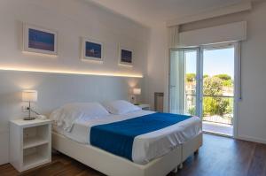 马尔米堡塔拉贝拉酒店的白色的卧室设有一张大床和一个窗户