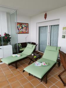 锡蒂奥卡拉翁达Mi Capricho的一间设有两张绿色椅子和一张沙发的房间