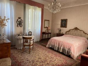 佛罗伦萨CASA LA TORRE un castello alle porte di Firenze的卧室配有1张床、1张桌子和1把椅子