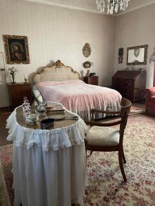 佛罗伦萨CASA LA TORRE un castello alle porte di Firenze的一间卧室配有一张床和一张桌子及一张桌子
