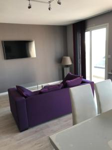 圣让-德蒙APPARTEMENT Résidence GARDENIAS SAINT JEAN DE MONTS的客厅配有紫色沙发和电视