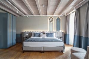维罗纳Relais Balcone di Giulietta的一间卧室配有一张带蓝色枕头的大床