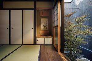 京都Kyoto Urushiro Wakasaya by YADORU KYOTO HANARE的滑动玻璃门和植物的房间