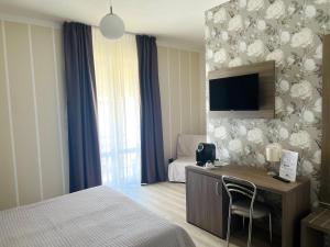 巴多利诺卡马萨瓦尔撒酒店的酒店客房配有一张床和一张书桌及一台电视