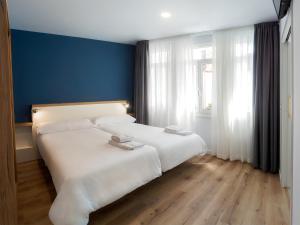 阿尔苏阿Casa do cabo的卧室配有白色的床和蓝色的墙壁