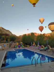格雷梅Grand Elite Cave Suites的一座大型游泳池,在天空中设有热气球