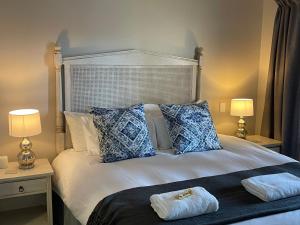 乔治Oubaai Golf Estate的一间卧室配有一张带两张桌子和两盏灯的床。