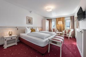 里约·迪·普斯特里亚Hotel Weisse Lilie - Giglio Bianco的酒店客房带一张大床和一把椅子