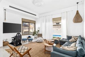 贝尔谢巴Perfect Villa的客厅配有蓝色的沙发和电视