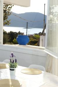 阿尔米洛波塔莫斯White Villa in Olive trees and Seaview to Panagia的白色的桌椅,享有窗户的景色