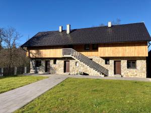 PribanjciMulina River Lodge的一座大型石头建筑,有黑色的屋顶