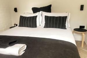 MarldonThe Cabin at Barnstormers, luxury woodland setting的一张白色大床,配有黑白枕头