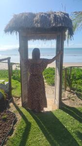 雅帕拉廷加Club Manguaba Beira Mar的女人站在海滩上的小屋里