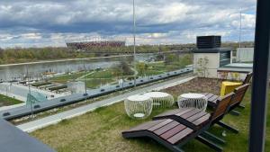 华沙Apartament Powiśle Deluxe的阳台设有长凳,享有体育场的景致。