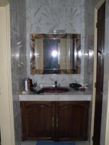 梅克内斯VILLA PLAISANCE的一间带红色水槽和镜子的浴室