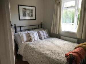 NarboroughMeal House的卧室配有带枕头的床铺和窗户。
