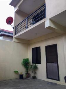 塔比拉兰Kylitas transient house- Bohol的带阳台和两株盆栽植物的建筑