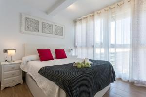 加的斯Apartments Vistas Mar Bahia的一间卧室配有一张带红色枕头的大床