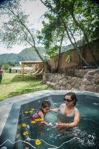 卡尔卡Unuwasi Hotel & Villa的游泳池里的女人和孩子