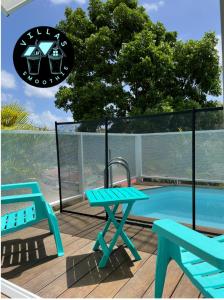 勒弗朗索瓦Villas Smoothie Papaya的一个带2个蓝色长椅和游泳池的庭院