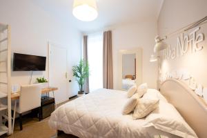 拉瓦尼亚提古丽奥酒店的白色卧室配有一张大床和一张书桌