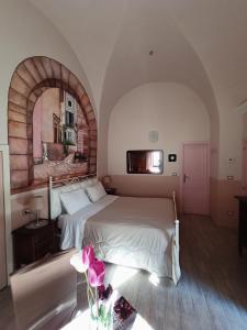 BovinoDormire nel Borgo的卧室配有白色的床和拱形窗户