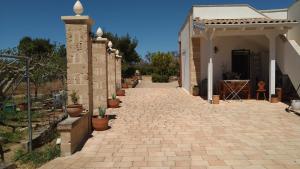 圣玛丽亚巴格诺Villa Aurora的一条砖砌的走道,通往一座种植了盆栽植物的房子