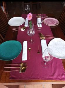 洛维奥斯Casa Rosalia的一张桌子,上面有紫色的桌布,盘子和眼镜