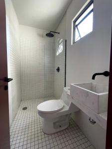 瓜达拉哈拉Casa Ixaya by Barrio México的白色的浴室设有卫生间和水槽。