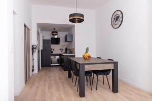 拉弗雷切Appartement 70m2 hyper centre avec baignoire balnéo的厨房以及带黑色桌椅的用餐室。