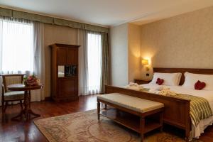 索阿韦罗克西广场酒店的酒店客房带一张床、一张桌子和椅子