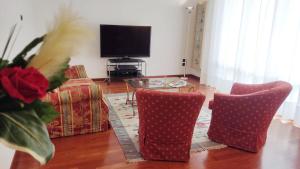 Castelfranco di SottoDiamante: Appartamento nel cuore della Toscana的客厅配有两把椅子、一张桌子和电视