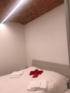 佛罗伦萨Elegante e spazioso bilocale in zona Certosa (FI)的一张带白色毛巾和红色弓的床