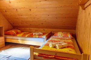 Koprivnik v BohinjuHoliday house Pokljuka - Bohinj的木墙客房的两张床