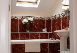 斯特灵Linden Apartment的浴室设有红色瓷砖墙壁和水槽
