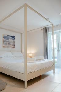 森嫩湾森嫩湾小屋酒店的白色的卧室配有白色的天蓬床