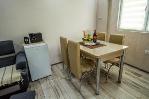 巴伊纳巴什塔Apartman Trijumf的餐桌、椅子和一瓶葡萄酒