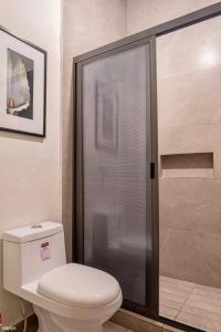 科利马HM HOTEL EXPRESS的一间带卫生间和玻璃淋浴间的浴室