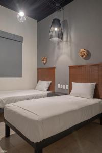 科利马HM HOTEL EXPRESS的一间带两张床和两盏灯的卧室