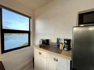 尤克卢利特Private Oceanfront Room With Hot Tub Firepit - Shore Thing的带冰箱和大窗户的厨房