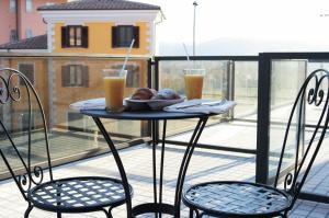 阿尼奥内伊尔都卡德尔桑尼奥酒店的阳台上的桌子上放着一盘食物和两杯饮料
