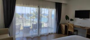 巴拉奥纳省圣克鲁斯Hotel El Quemaito - Luxury Oceanfront Retreat的一间卧室设有大窗户,享有度假村的景色