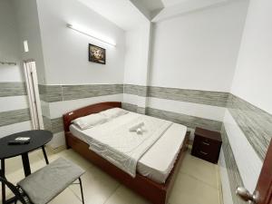 胡志明市Huy Hoàng Hotel的一间小卧室,配有一张床和一张桌子