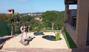 马斯萨内特德拉塞尔瓦VILLA BLANCA 10 minutos de la Playa Costa brava的一座花园,旁边是一座雕像