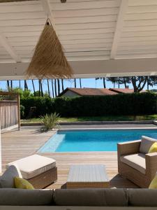 居让梅斯特拉Maison avec sa grande terrasse ensoleillée的带沙发和游泳池的天井