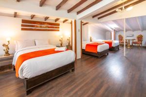 库斯科Hotel Monasterio del Inka的一间大卧室,配有两张床和一张桌子