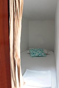 卡塔赫纳República Hostel Cartagena的一张小床,位于带窗帘的房间
